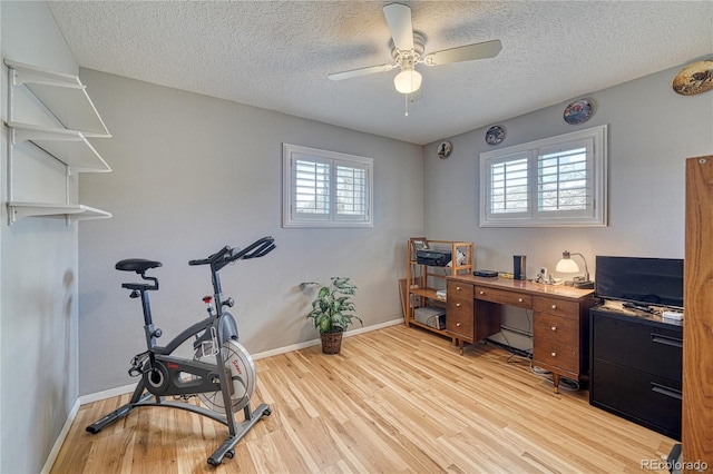 office space with light wood-style floors, baseboards, and a textured ceiling