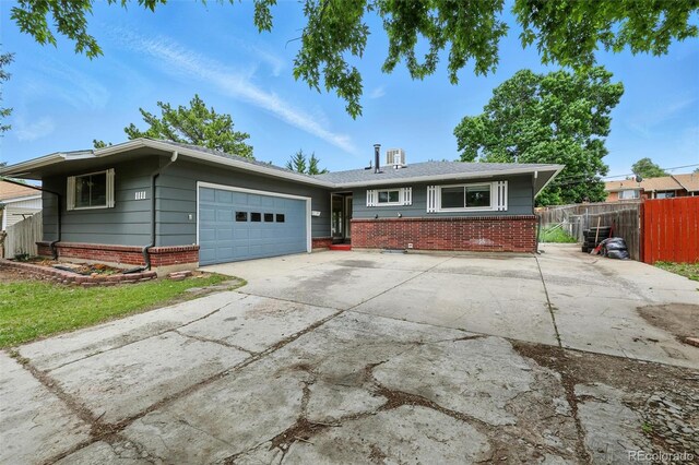 1111 Royale Dr, Colorado Springs, CO 80910 - ranch-style house with brick siding, an attached garage, and driveway