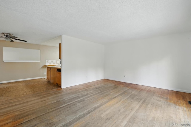 1111 Royale Dr, Colorado Springs, CO 80910 - unfurnished living room with wood-type flooring, a ceiling fan, and a textured ceiling