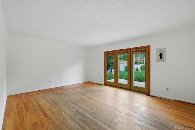 1111 Royale Dr, Colorado Springs, CO 80910 - empty room featuring light wood-style floors, electric panel, french doors, and a textured ceiling