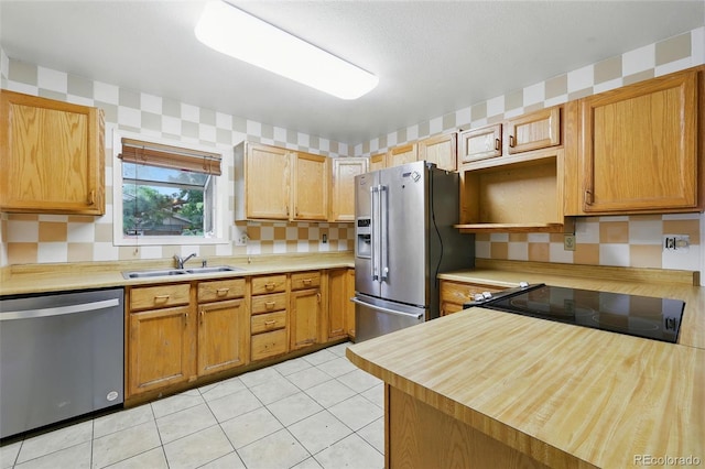1111 Royale Dr, Colorado Springs, CO 80910 - kitchen with appliances with stainless steel finishes, wallpapered walls, and light tile patterned floors