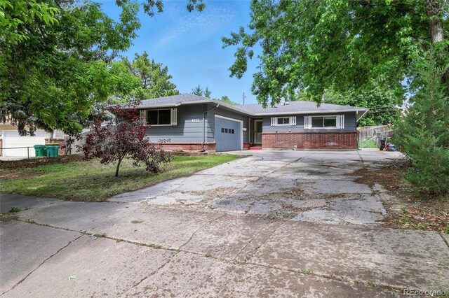 1111 Royale Dr, Colorado Springs, CO 80910 - view of front of home with brick siding, a garage, and driveway
