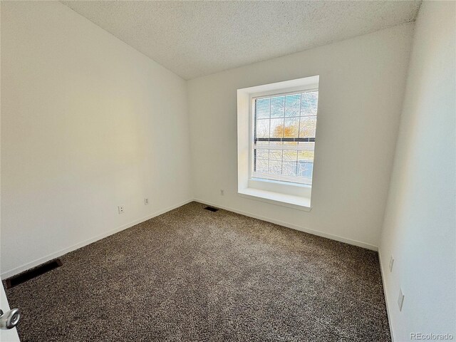 carpeted empty room with a textured ceiling