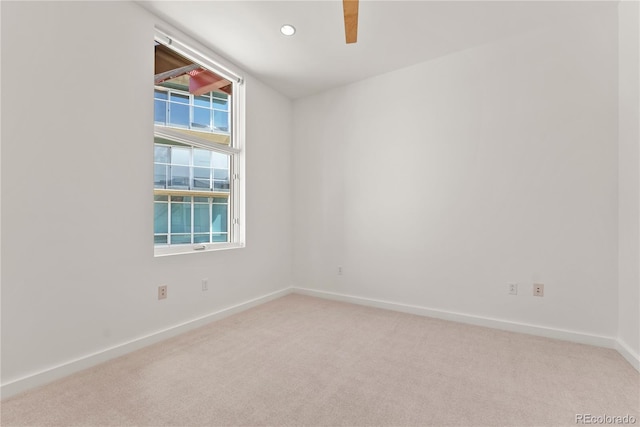 unfurnished room with recessed lighting, baseboards, and light carpet