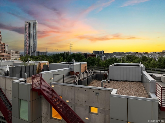 balcony at dusk featuring a view of city