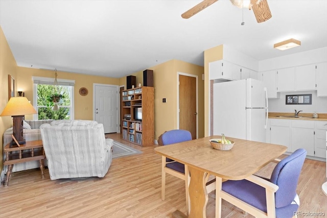 dining area featuring light wood-type flooring and ceiling fan