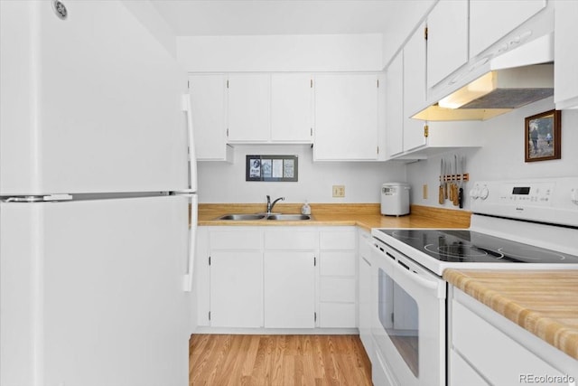 kitchen featuring white appliances, a sink, light countertops, and light wood finished floors