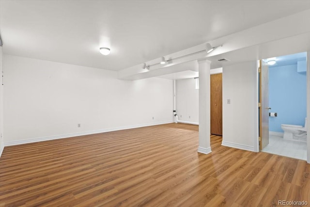 finished basement featuring wood finished floors and baseboards
