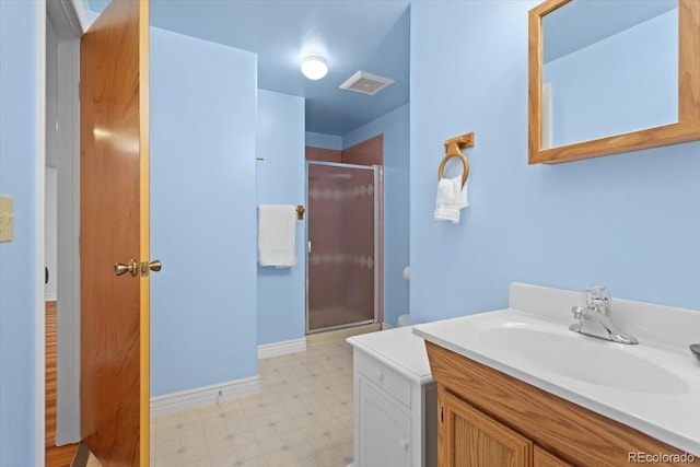bathroom with tile patterned floors, a shower stall, vanity, and baseboards