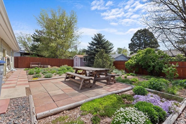 view of patio featuring a shed, a fenced backyard, and an outbuilding