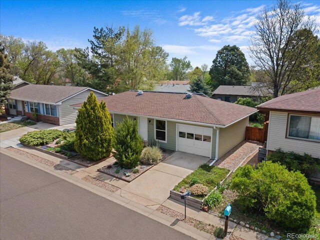 ranch-style house featuring fence, an attached garage, driveway, and central air condition unit