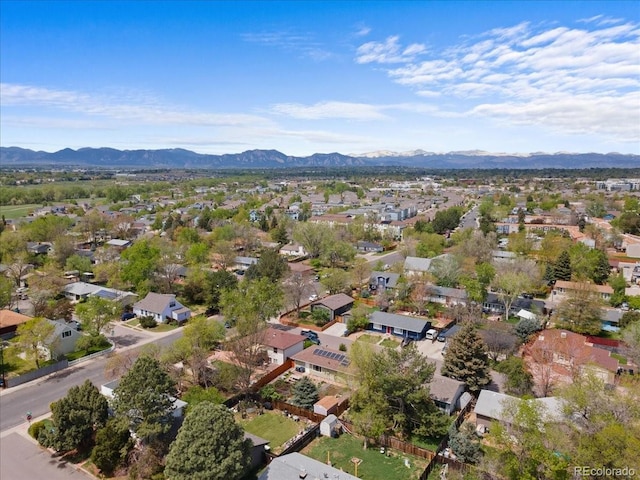 aerial view of property and surrounding area featuring a mountainous background and nearby suburban area