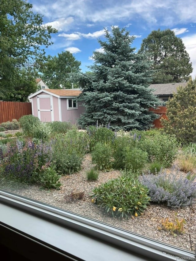 view of yard with a shed, fence, and an outdoor structure