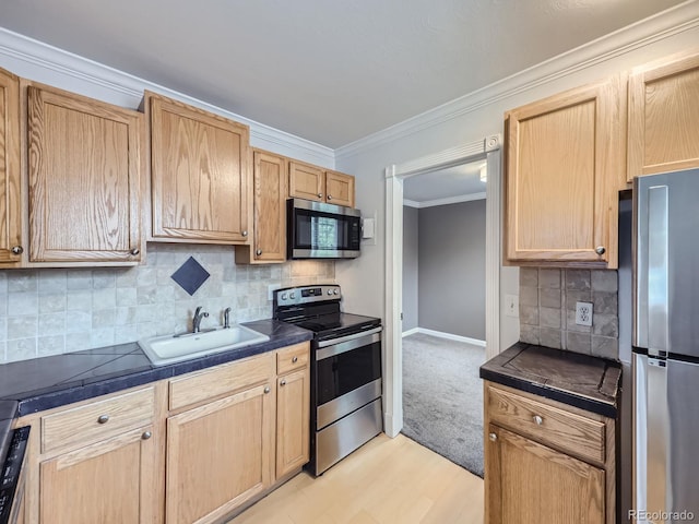 kitchen with ornamental molding, light brown cabinets, a sink, appliances with stainless steel finishes, and baseboards