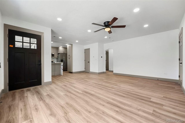 unfurnished living room featuring ceiling fan and light wood-type flooring