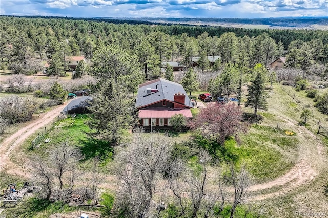 aerial view of property and surrounding area with a forest