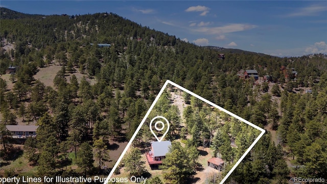 32187 Sylvan Rd, Golden, CO 80403 - aerial view of property and surrounding area with a forest, property boundaries highlighted, and a mountainous background
