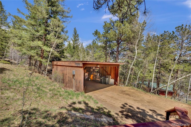 32187 Sylvan Rd, Golden, CO 80403 - view of pole building featuring a wooded view and concrete driveway