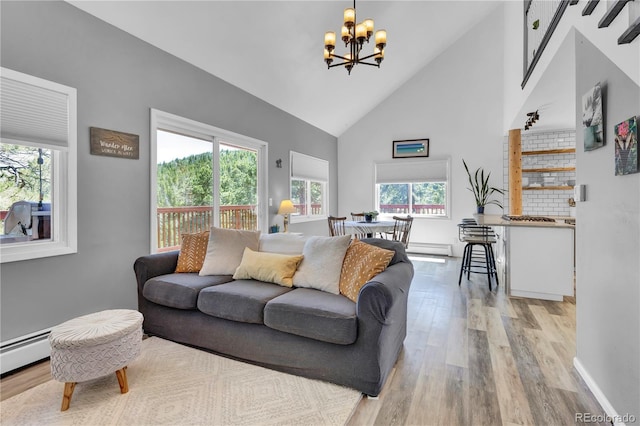 32187 Sylvan Rd, Golden, CO 80403 - living room featuring high vaulted ceiling, a chandelier, healthy amount of natural light, light wood-style floors, and a baseboard heating unit