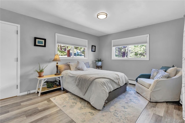 32187 Sylvan Rd, Golden, CO 80403 - bedroom featuring multiple windows, baseboard heating, and wood finished floors