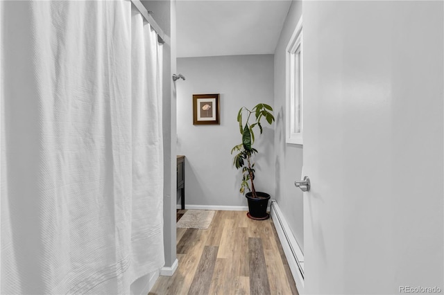 32187 Sylvan Rd, Golden, CO 80403 - full bathroom featuring baseboard heating, wood finished floors, and a shower with curtain