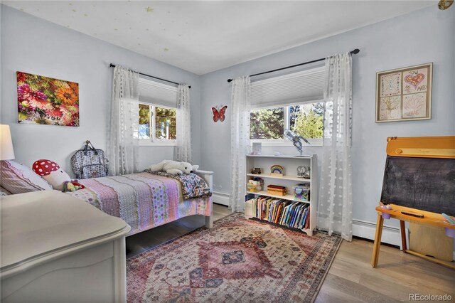 32187 Sylvan Rd, Golden, CO 80403 - bedroom with wood finished floors, a baseboard radiator, and baseboard heating