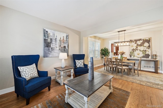 living room featuring hardwood / wood-style flooring and an inviting chandelier