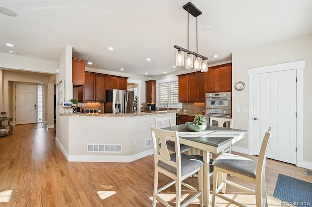 dining space with sink and light hardwood / wood-style floors