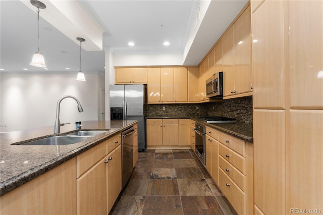 kitchen featuring hanging light fixtures, appliances with stainless steel finishes, light brown cabinetry, dark stone countertops, and sink