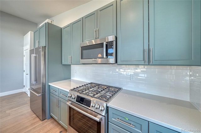 kitchen with backsplash, light hardwood / wood-style floors, and high end appliances