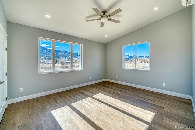 empty room with wood-type flooring, vaulted ceiling, a wealth of natural light, and ceiling fan