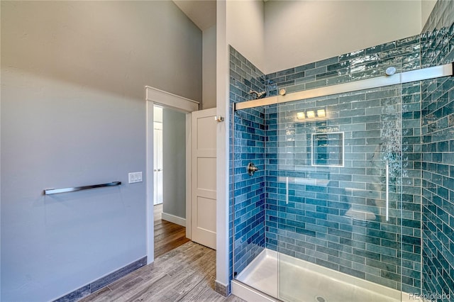 bathroom featuring wood-type flooring and an enclosed shower