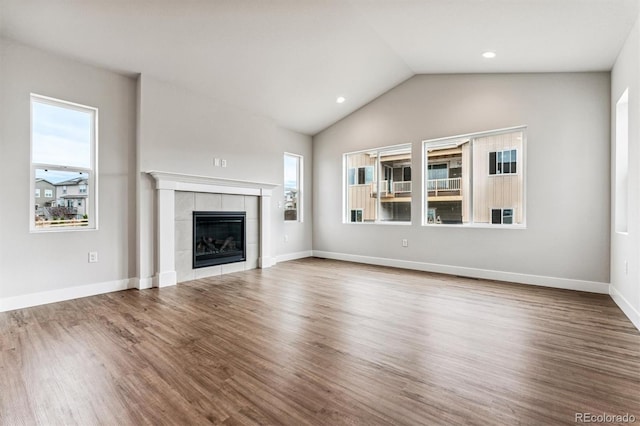 unfurnished living room with a fireplace, wood-type flooring, and lofted ceiling