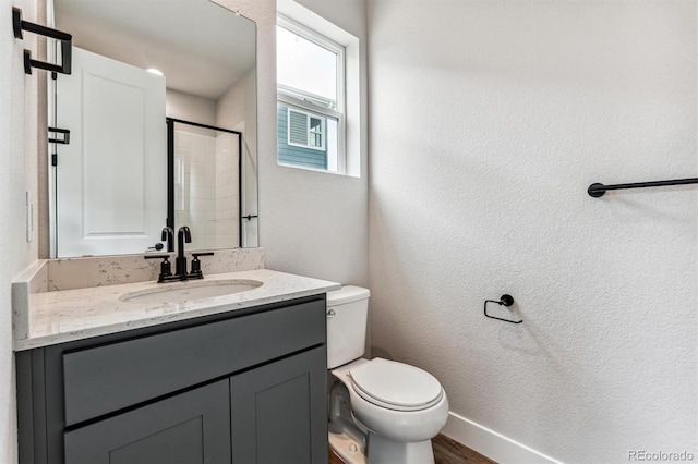 bathroom with wood-type flooring, vanity, toilet, and walk in shower