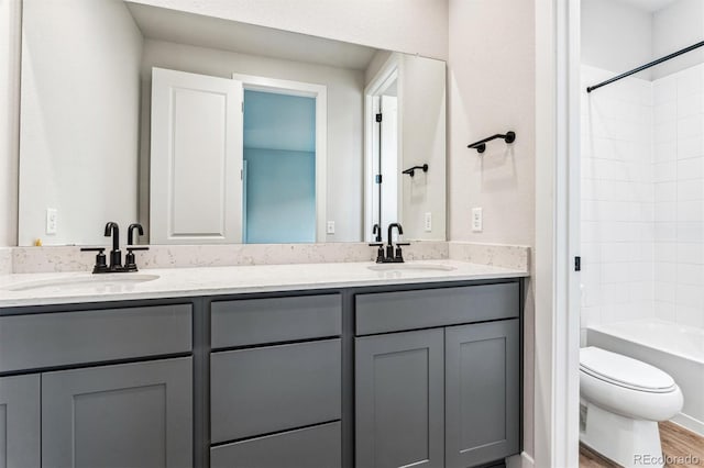 full bathroom with shower / washtub combination, vanity, wood-type flooring, and toilet