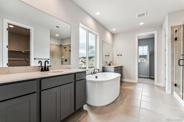 bathroom featuring tile patterned flooring, shower with separate bathtub, vanity, and a healthy amount of sunlight