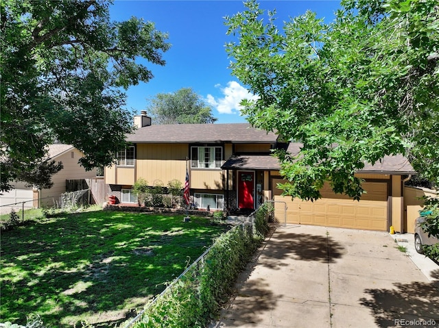 view of front facade with an attached garage, fence, concrete driveway, a chimney, and a front yard