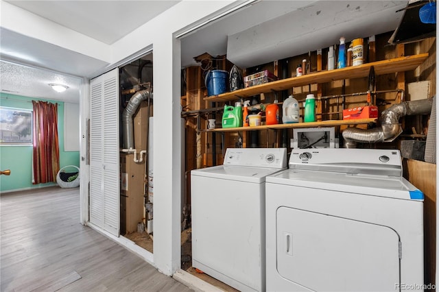 washroom featuring washing machine and dryer, laundry area, and light wood finished floors