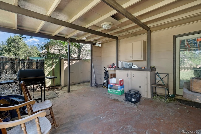 view of patio / terrace with an outbuilding, a shed, area for grilling, and fence