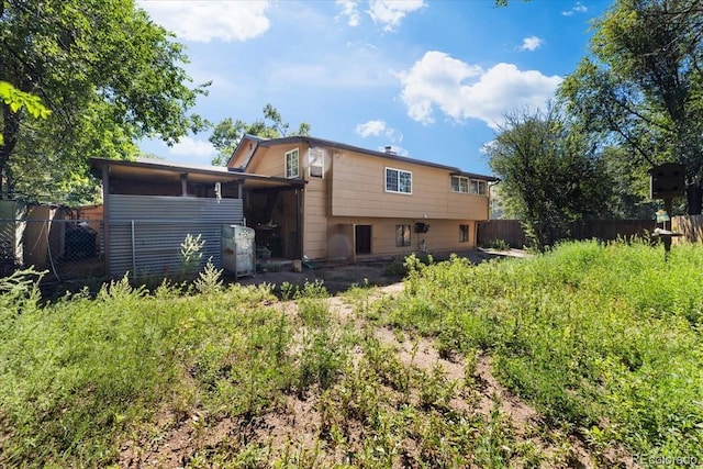 rear view of property featuring fence