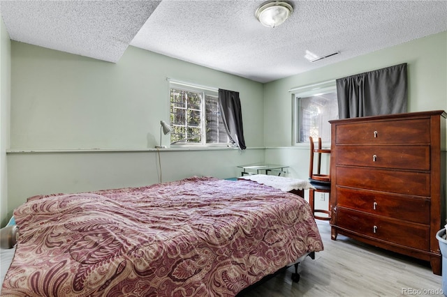 bedroom with wood finished floors and a textured ceiling