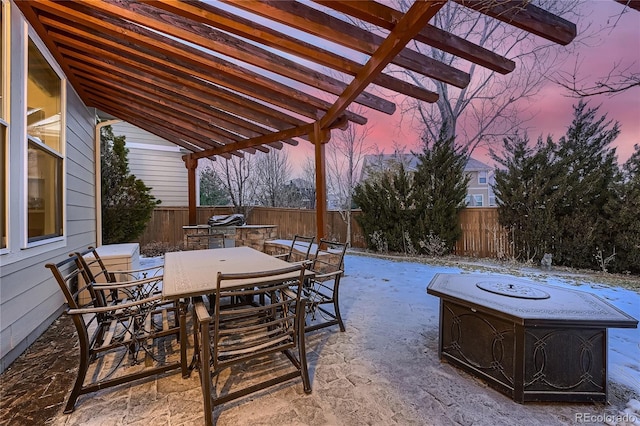 snow covered patio featuring a pergola and a fire pit