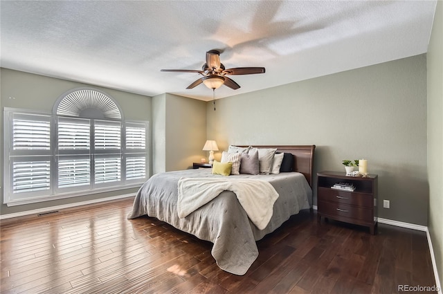 bedroom featuring ceiling fan, dark hardwood / wood-style flooring, and a textured ceiling