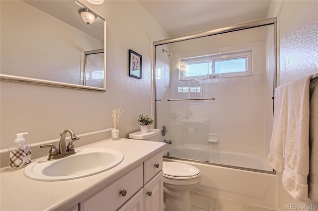 full bathroom featuring shower / bath combination with glass door, vanity, toilet, and tile patterned flooring