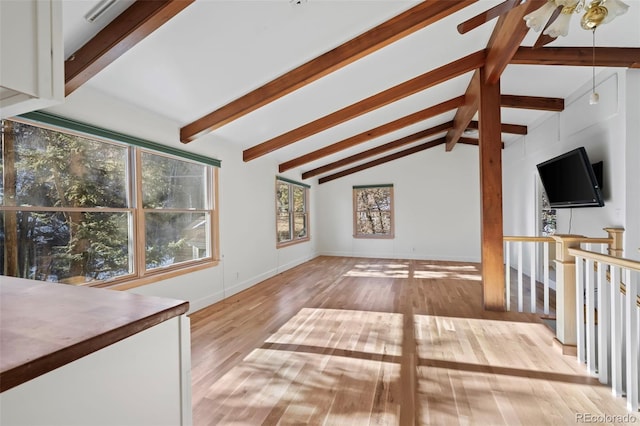 unfurnished living room featuring vaulted ceiling with beams, ceiling fan, and light hardwood / wood-style flooring