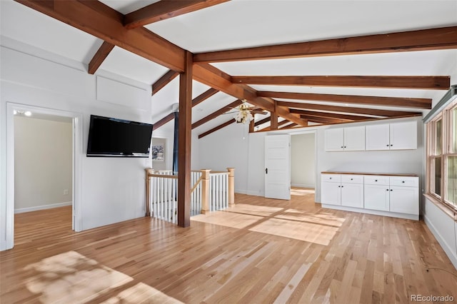 unfurnished living room featuring vaulted ceiling with beams, light hardwood / wood-style flooring, and ceiling fan