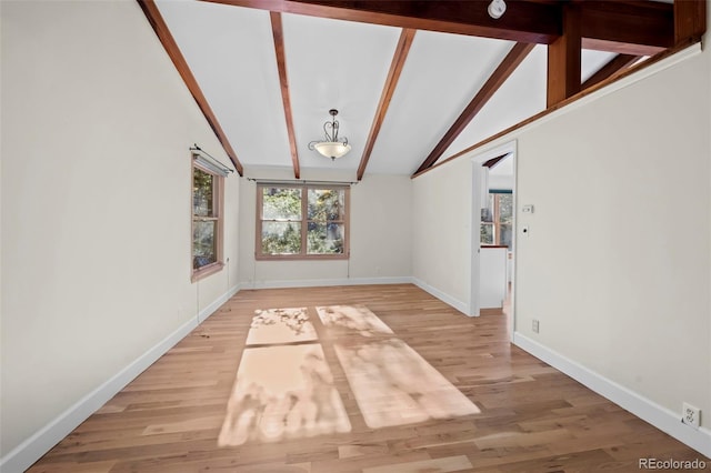 unfurnished dining area featuring hardwood / wood-style floors and lofted ceiling with beams