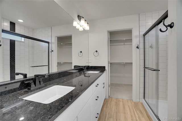 10124 Xanadu St, Commerce City, CO 80022 - full bath featuring a stall shower, wood finished floors, double vanity, and a sink