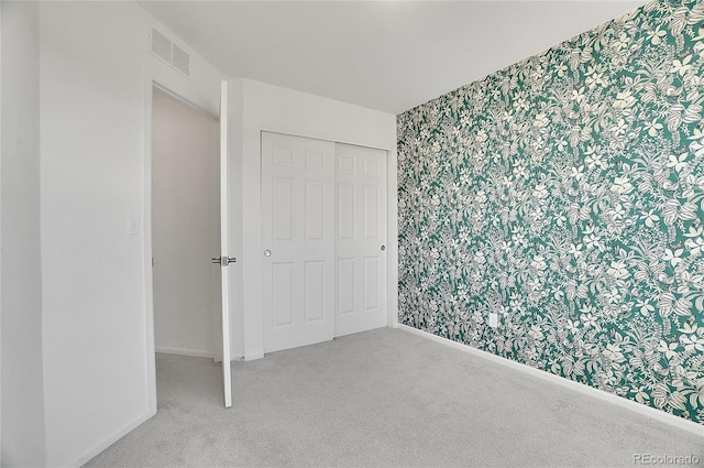 10124 Xanadu St, Commerce City, CO 80022 - unfurnished bedroom featuring a closet, visible vents, carpet flooring, wallpapered walls, and baseboards