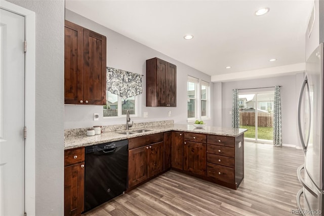 329 S 3rd Ave, Deer Trail, CO 80105 - kitchen with dishwasher, light wood-type flooring, a peninsula, refrigerator, and light stone counters